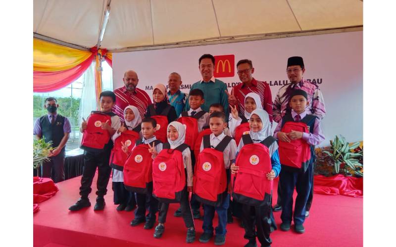 Azmir (kanan) dan Kok Seong (kiri) bergambar bersama sebahagian daripada 800 kanak-kanak di Negeri Sembilan yang menerima sumbangan Pek Kembali Ke Sekolah.