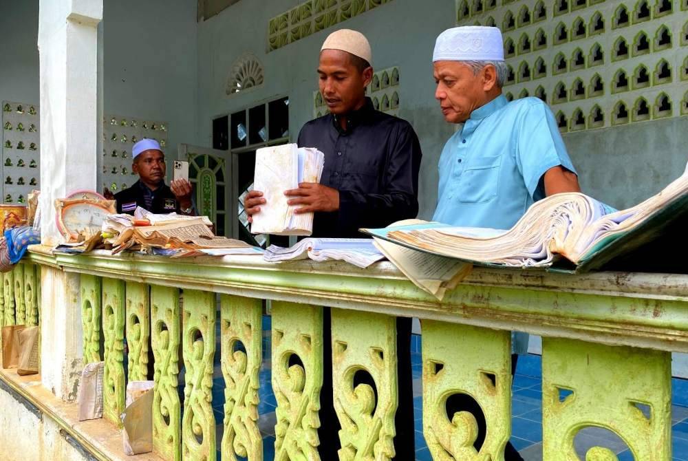 Ilyas (dua dari kanan) menunjukkan kepada Muhammad Nasir kerosakan yang berlaku di masjid.