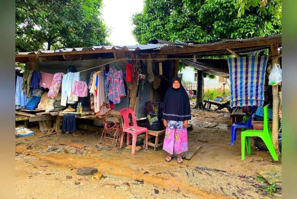 Kamalo di hadapan bangsal yang kini menjadi tempat tinggal mereka selepas rumah dihanyut banjir.