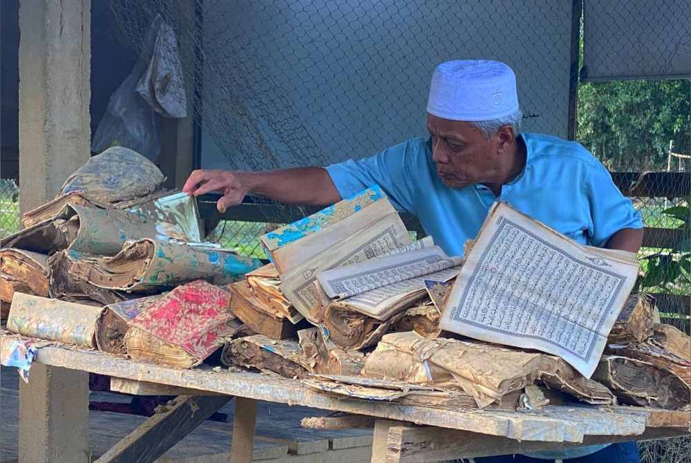 Muhammad Nasir sebak melihat keadaan kitab suci al-Quran yang rosak akibat ditenggelami banjir baru-baru ini.