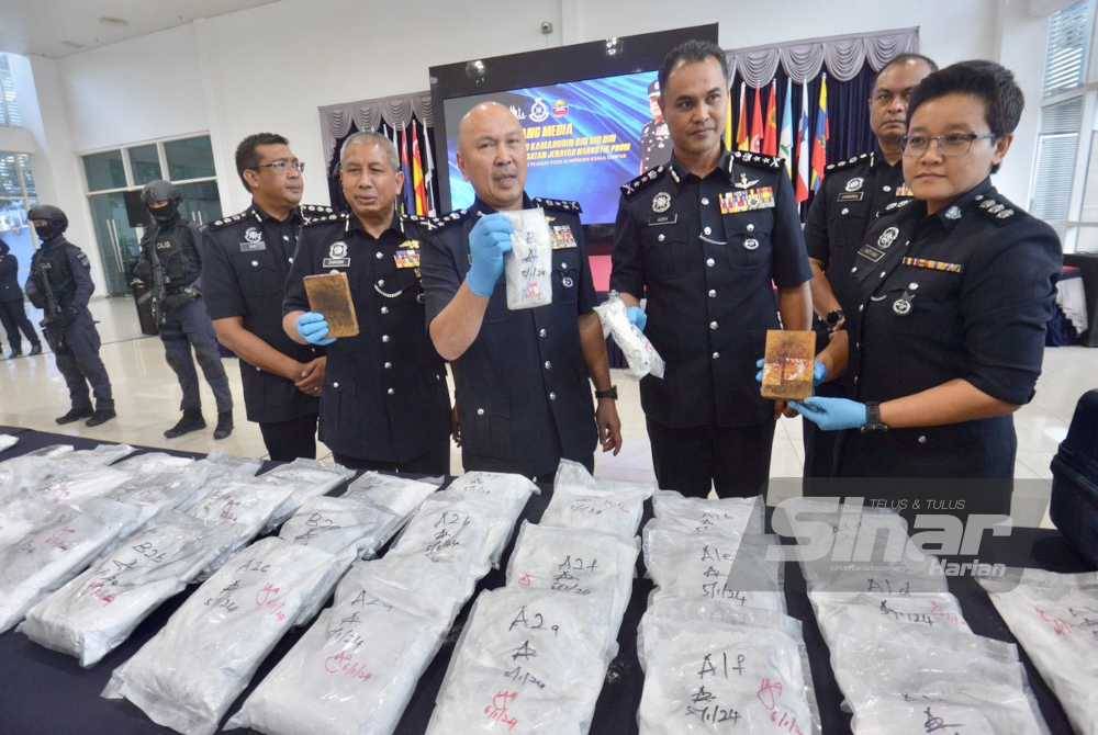 Kamarudin menunjukkan dadah yang dirampas.