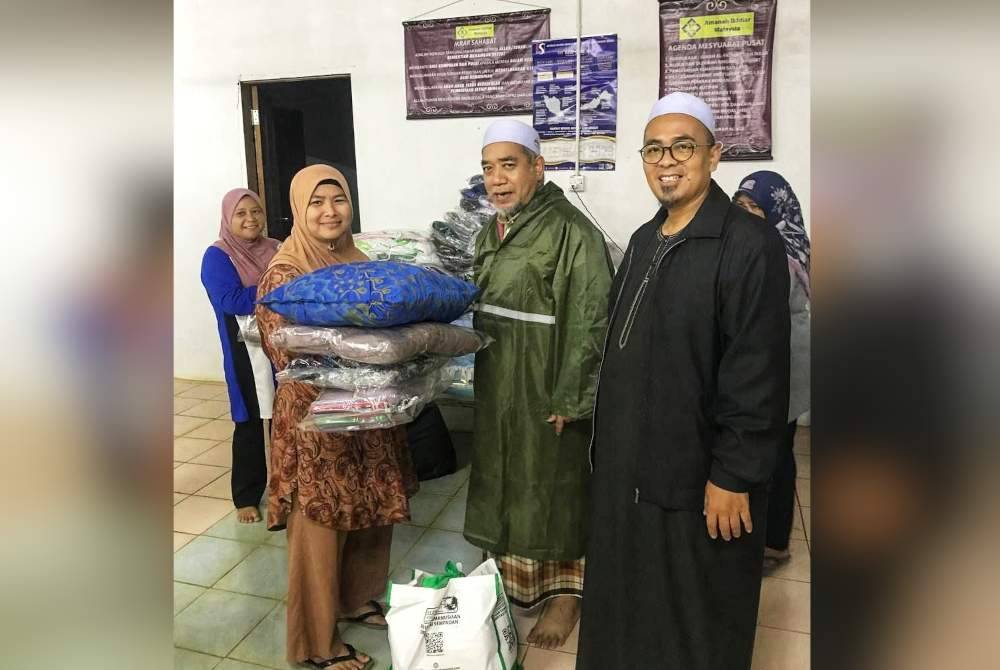 Antara barangan keperluan yang disampaikan oleh Kamal (tengah) kepada mangsa banjir di PPS Balai Raya Felda Jengka 17.