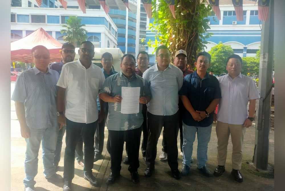 Ahmad Ikhwan (depan, tiga dari kiri) selepas membuat laporan polis di IPD Dang Wangi, Kuala Lumpur pada Rabu.