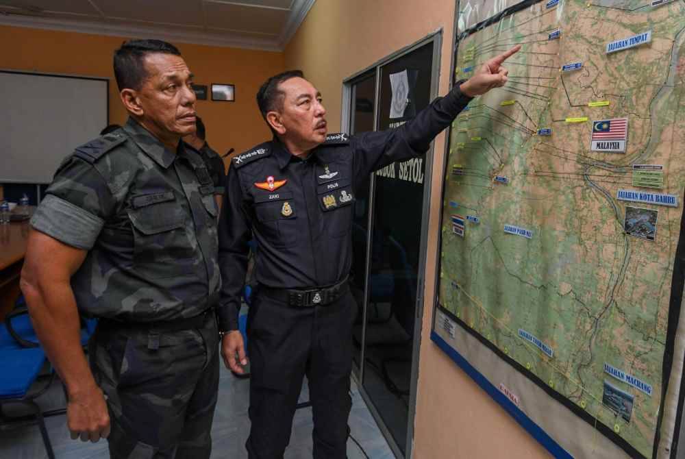 Muhamad Zaki (kanan) bersama Komander Briged Tenggara Pasukan Gerakan Am (PGA) Senior Asisten Komisioner, Sheik Azhar Sheik Omar menunjukkan pelan lokasi operasi di sebahagian sempadan selepas Mesyuarat Bersama Agensi Penguatkuasa Sempadan di Markas Taktikal PGA di Lubok Setol hari ini. Foto Bernama