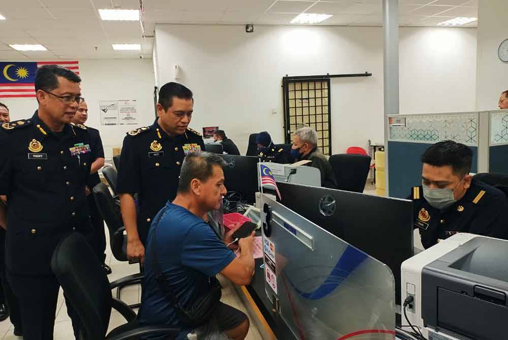 Aedy Fadly (dua dari kiri) ketika meninjau pelaksanaan cetakan slip pembaharuan LMM di Pusat Transformasi Bandar (UTC) Perak di Ipoh pada Rabu.