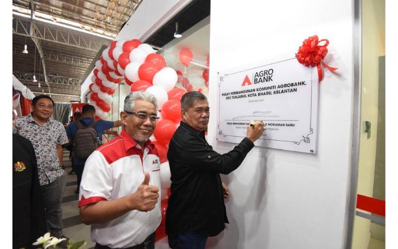 Mohamad menandatangani plak perasmian premis Pusat Pembangunan Komuniti Agrobank di RTC Tunjung.
