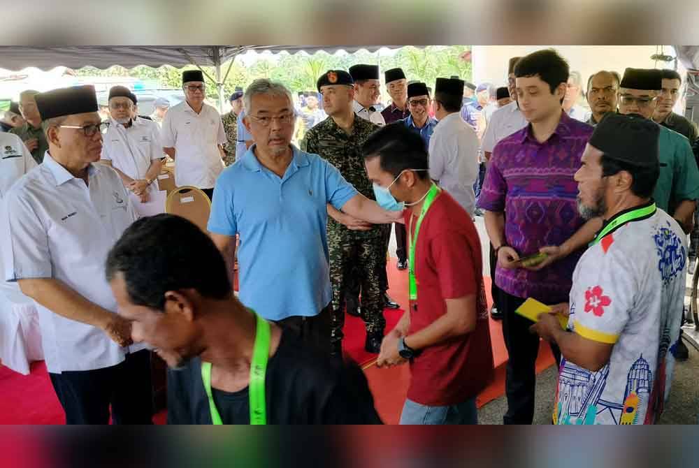 Al-Sultan Abdullah menyampaikan kurniaan kepada mangsa banjir di PPS Dewan Semai Bakti Felda Chini 1, di sini yang dilawati Seri Paduka Baginda pada Khamis