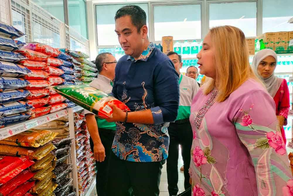Mohd Noor Helmy (kiri) dan Norena (dua dari kiri) melihat pelbagai jenama beras tempatan yang dijual di Lotus’s Mart Duyong di Taman Desa Duyong pada Khamis.