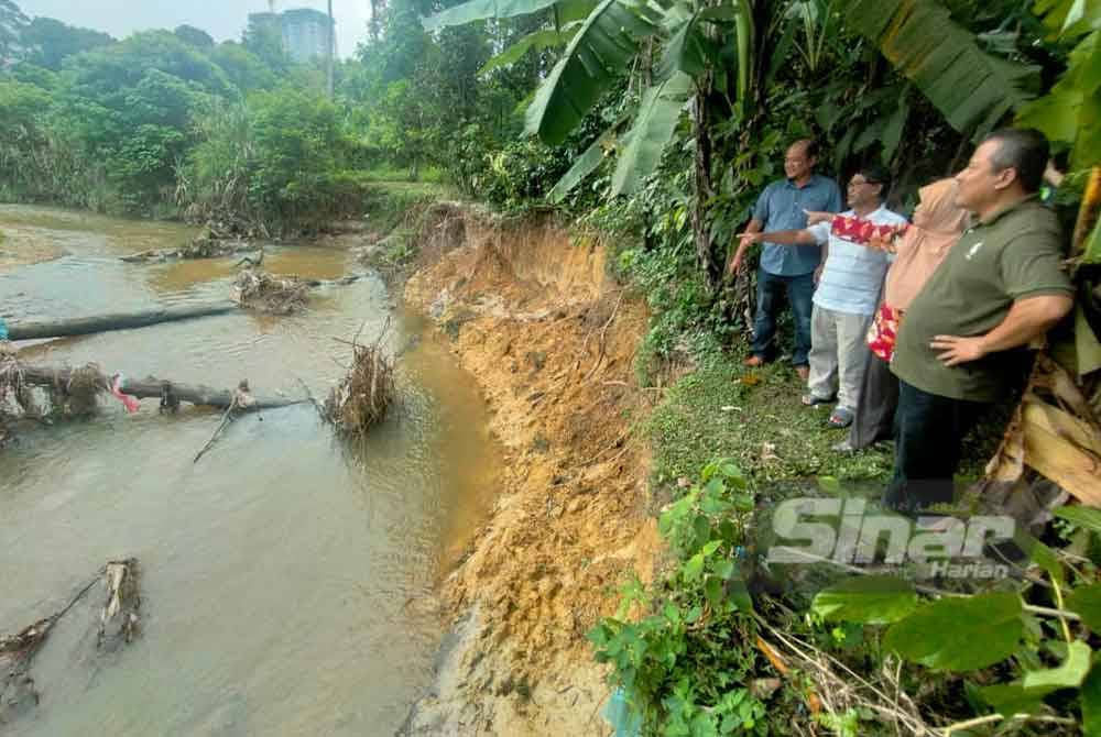 Rubiah (dua dari kanan) menunjuk ke arah jajaran sungai yang didakwa sudah berubah selepas kawasan itu dilanda banjir Disember lalu.