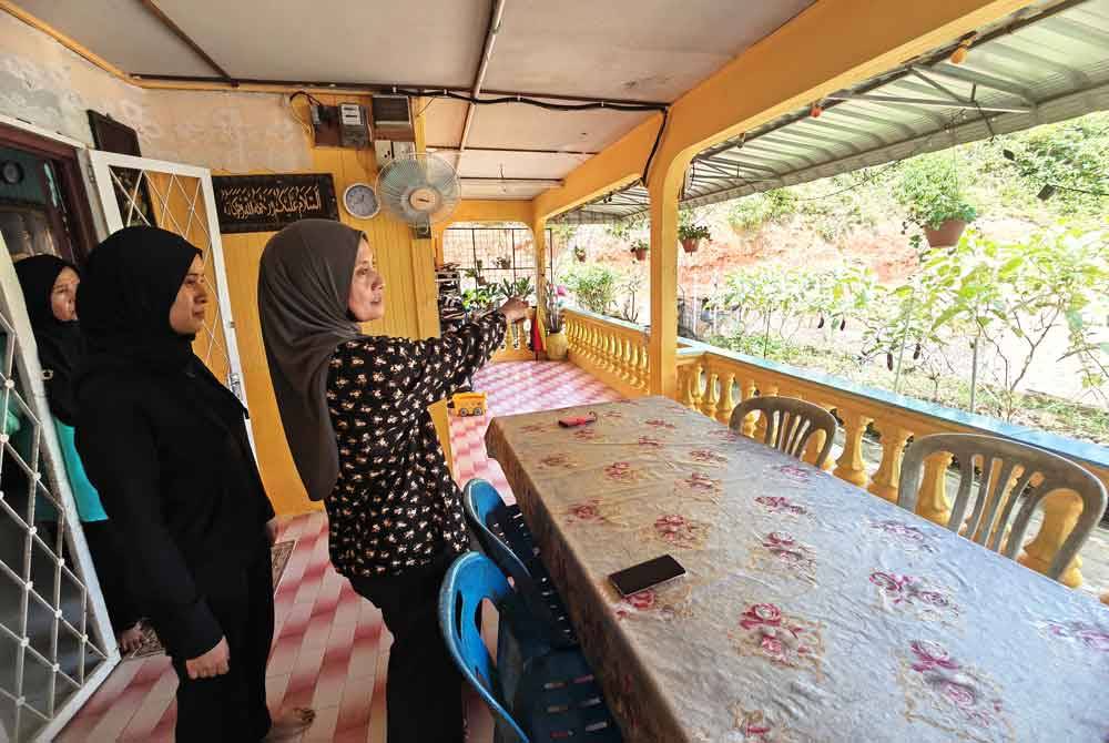 Marina menunjukkan lokasi lembaga hitam yang berdiri di luar beranda rumahnya.