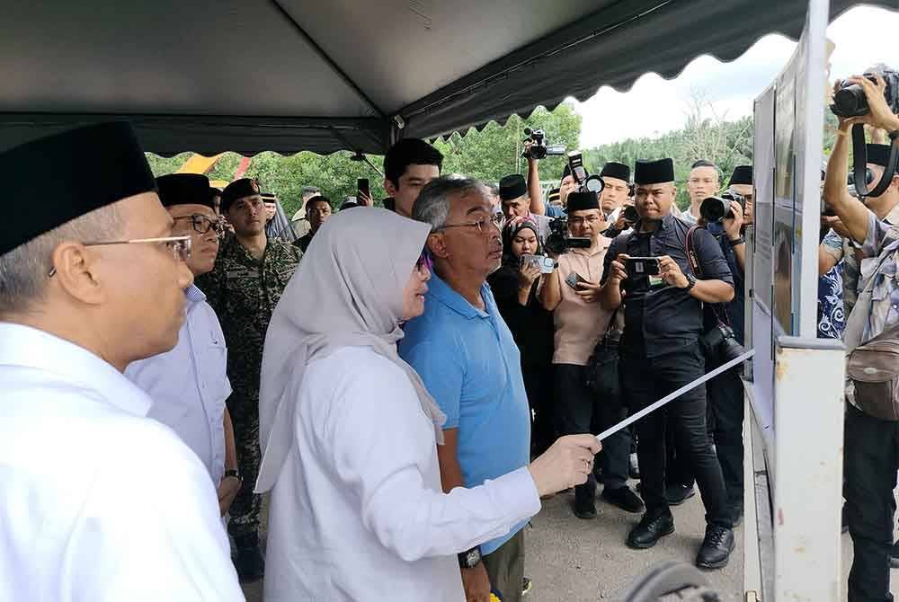 Al-Sultan Abdullah diberikan taklimat disampaikan Hafizah tentang situasi semasa kerja-kerja pembaikan jalan termasuk pemasangan jambatan bailey di laluan mendap di Kilometer 73 Jalan Kuantan-Segamat di sini.