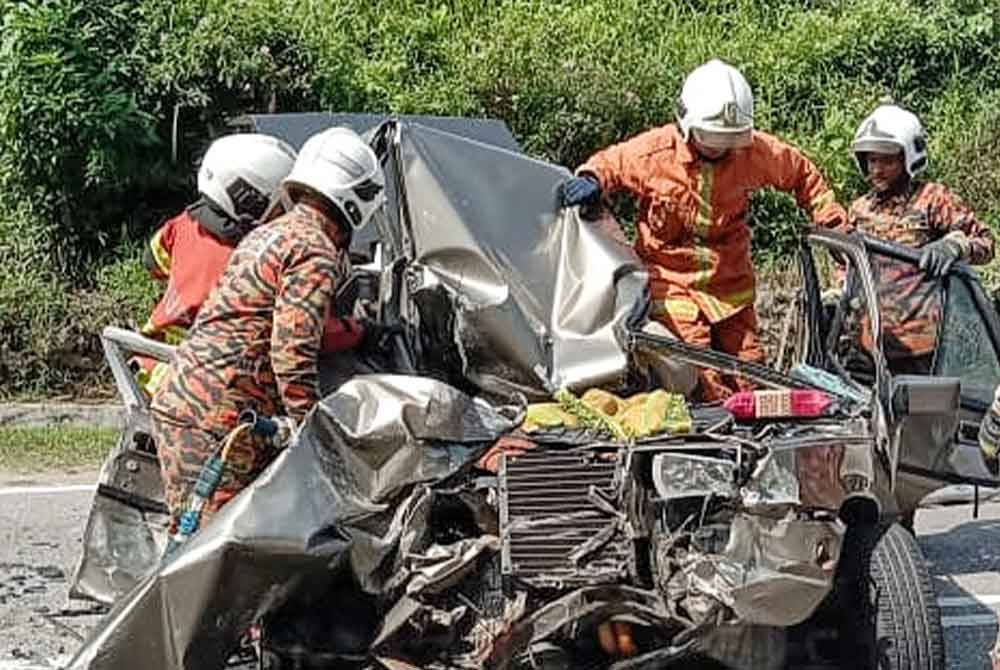 Anggota bomba melakukan kerja-kerja mengeluarkan mangsa dari kenderaannya.