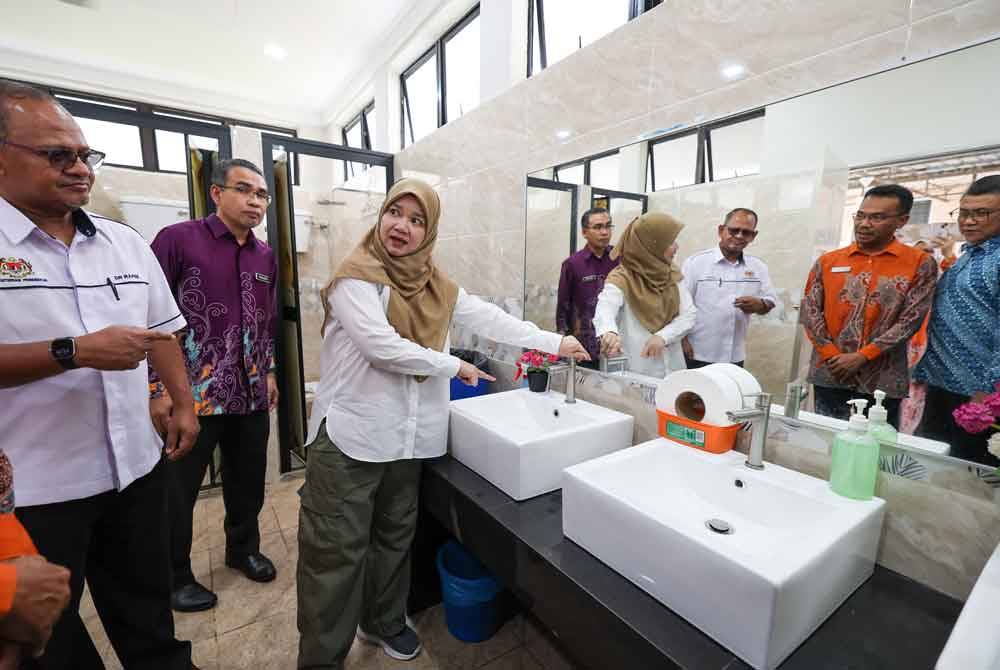 Fadhlina (tiga dari kiri) ketika melakukan lawatan kerja berikutan gangguan bekalan air di SMK Seri Nibong. Foto Bernama