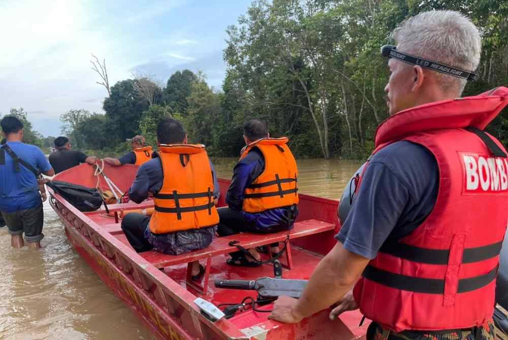 Kedua-dua mangsa dibawa keluar dari kawasan banjir oleh anggota bomba menggunakan sebuah bot.