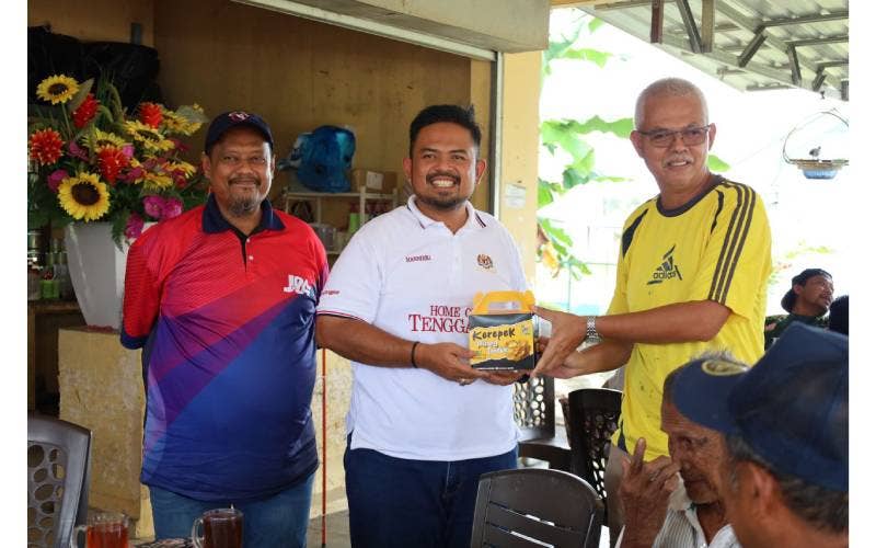 Manndzri (tengah) menyerahkan produk makanan keluaran usahawan tempatan yang mendapat manfaat bantuan RISDA kepada Pengerusi Felda Bukit Ramun, Mahadir Mohd Tahar (kanan) sempena lawatan tanah rancangan itu baru-baru ini. 