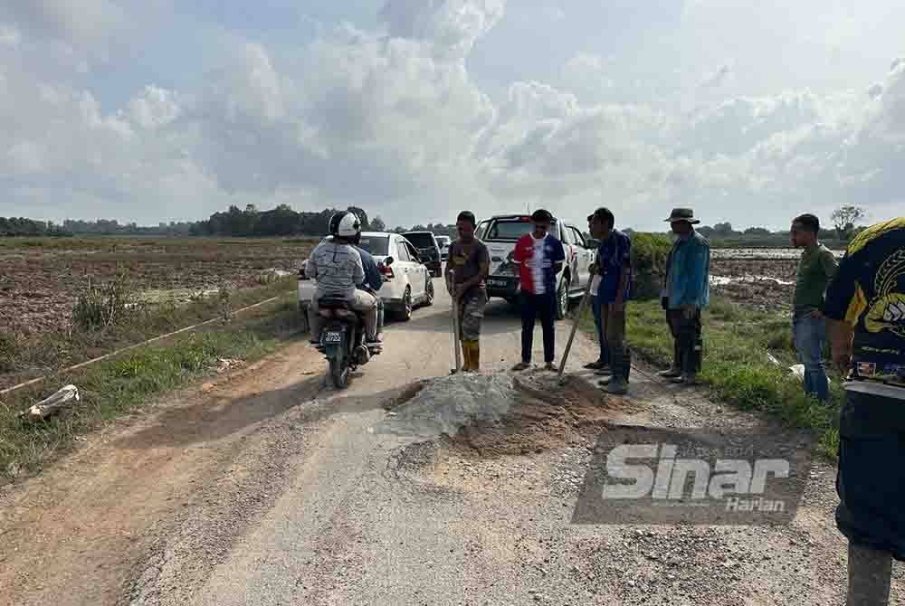 Penduduk bergotong-royong baiki jalan rosak di Kampung Kuala Jambu.