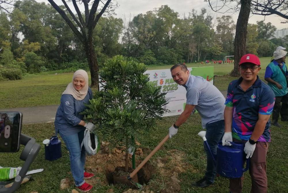 Sze Han (dua dari kanan) menyempurnakan Program Penanaman Pokok: Pledge an Plant A Tree di Bukit Kinrara pada Sabtu.