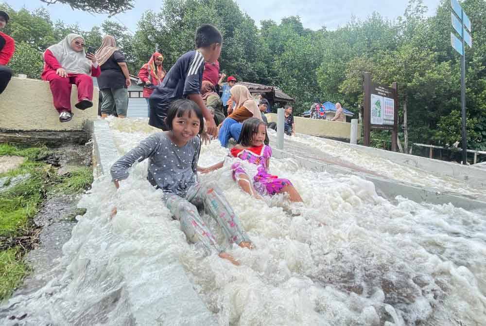 Kanak-kanak bermandipmanda di kawasan anak tangga laluan masuk Taman Negar Johor Tanjung Piai ketika air pasang besar pada Sabtu.