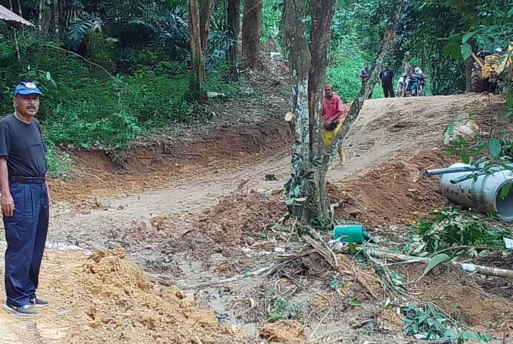 Wan Azman meninjau pembinaan jalan sementara ke Kampung Janggut Seberang pada Ahad.