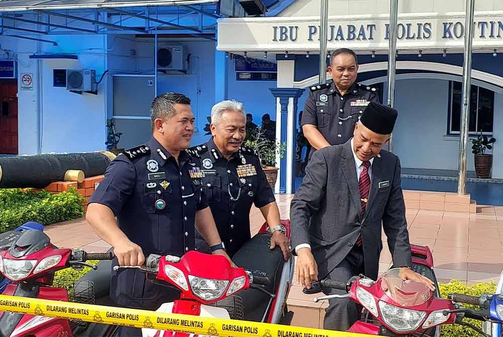 Mazli (kiri) memeriksa motosikal yang dilucut hak