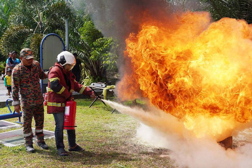 Salah seorang penduduk mencuba memadamkan kebakaran ketika Program Keselamatan Bersama Pasukan Bomba dan Penyelamat Dengan Persatuan Penduduk Taman Bentara 10, Teluk Panglima Garang pada Ahad.