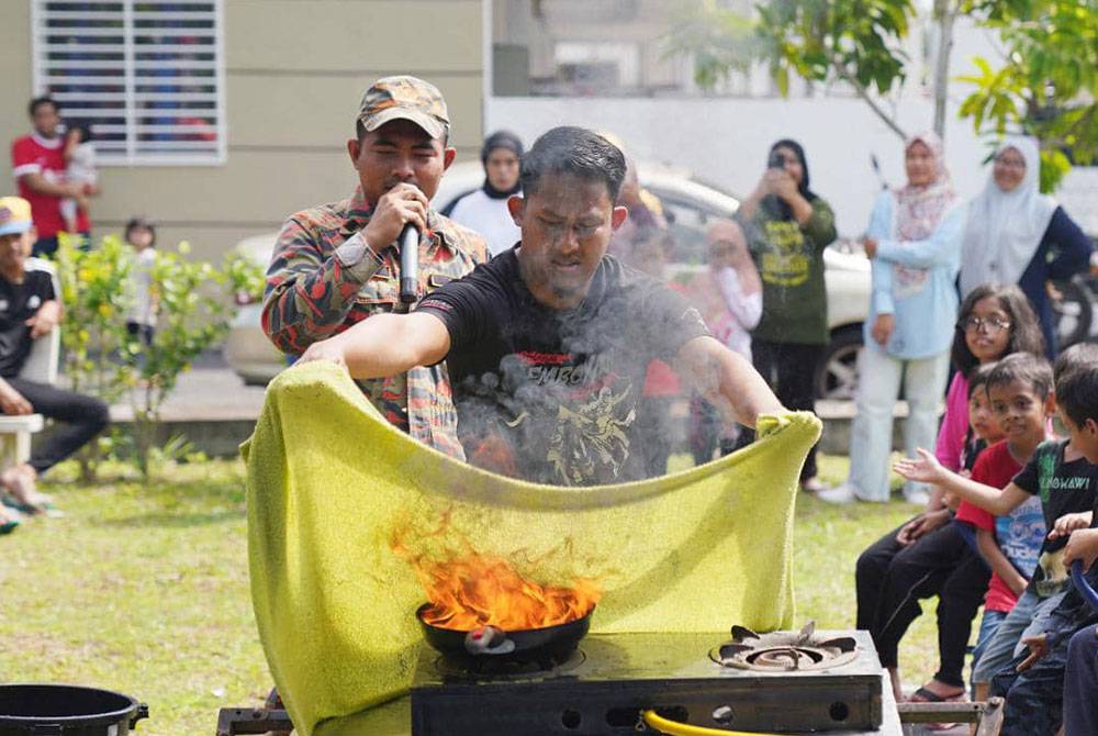 Salah seorang penduduk mencuba memadamkan kebakaran ketika Program Keselamatan Bersama Pasukan Bomba dan Penyelamat Dengan Persatuan Penduduk Taman Bentara 10, Teluk Panglima Garang pada Ahad.