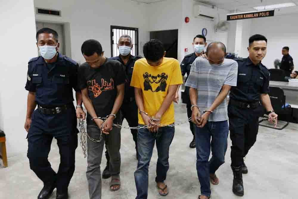 Muhammad Shafie (dua dari kiri), Mohd Ariffadilan (tengah) dan Mohd Zurmi (dua dari kanan) dikawal ketat polis menuju ke lokap Mahkamah Kota Bharu.