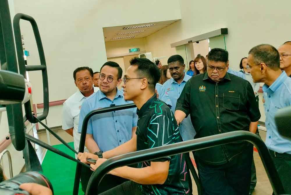Steven (kiri) melihat seorang pesakit yang sedang menjalani rawatan pemulihan di Pusat Rehabilitasi PERKESO Tun Abdul Razak di Ayer Keroh pada Isnin.