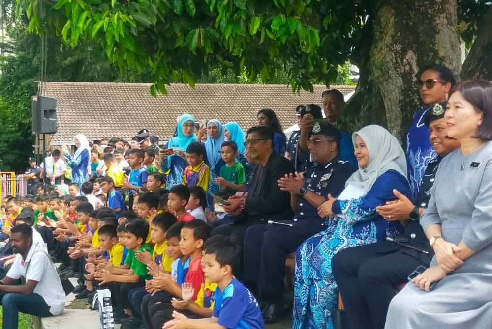 Allaudeen (duduk belakang, empat dari kanan) meluangkan masa bersama pelajar SK Lelaki Jalan Batu menyaksikan persembahan anjing polis daripada Unit K9 semasa program Back To School pada Selasa.