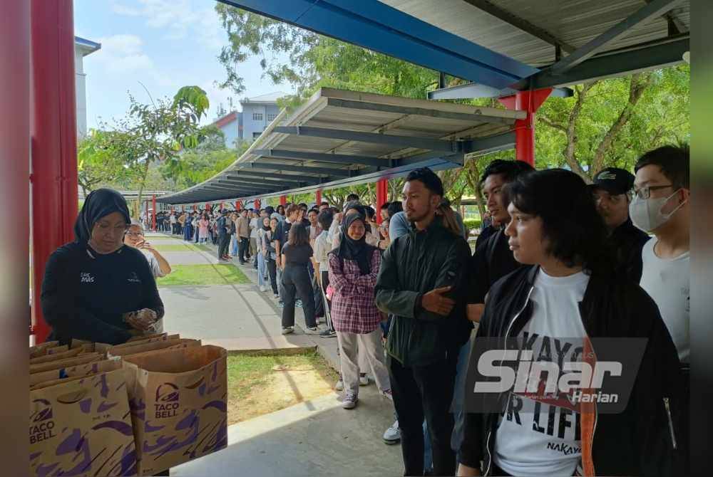 Pelajar beratur untuk mendapatkan pek makanan percuma dalam Program Taco Bell Give Away di Central Plaza, Universiti Multimedia pada Selasa.