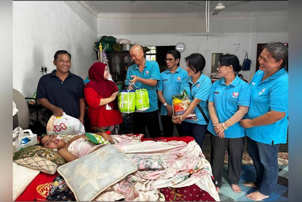 Tiong Lam (tiga dari kiri) menyampaikan sumbangan kepada Siti Noor Mastubaidura (dua dari kanan).