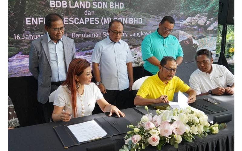 Pengarah Eksekutif Bina Darulaman Berhad (BDB), Raja Shahreen Raja Othman (duduk, tengah) mewakili Bina Darulaman Land dan Presiden, Enfiniti Group of Companies, Puan Sri Tiara Jacquelina (duduk, kiri) menandatangani MoU bagi membangunkan eko-pelancongan di Darulaman Sanctuary, Langkawi, semalam.