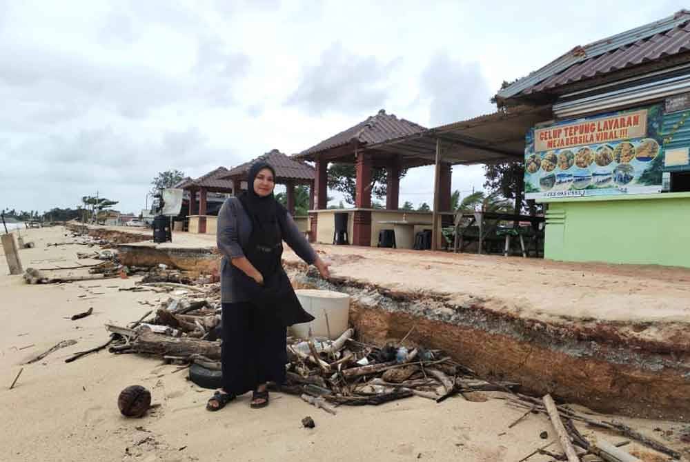 Azlieya menunjukkan kerosakan yang berlaku disepanjang jalan antara gerai makan dan kawasan pantai.