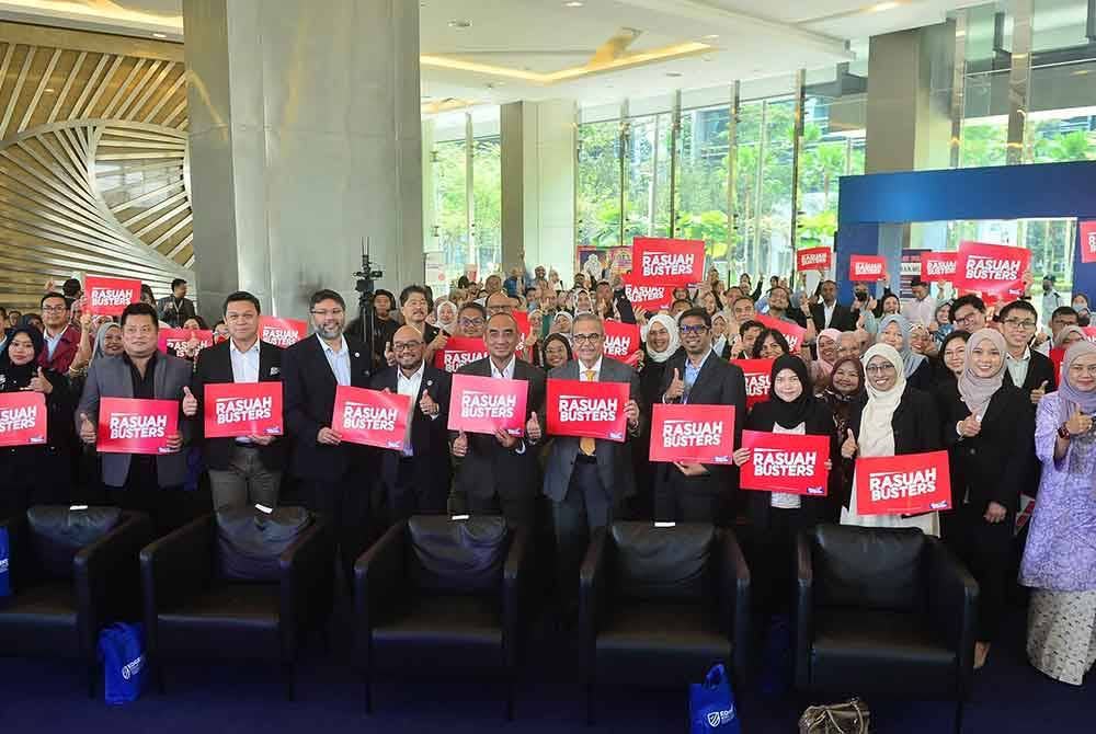 Warga kerja UEM Edgenta Berhad memegang plakad Rasuah Busters sempena Integrity Day 2024. Foto ASRIL ASWANDI SHUKOR.