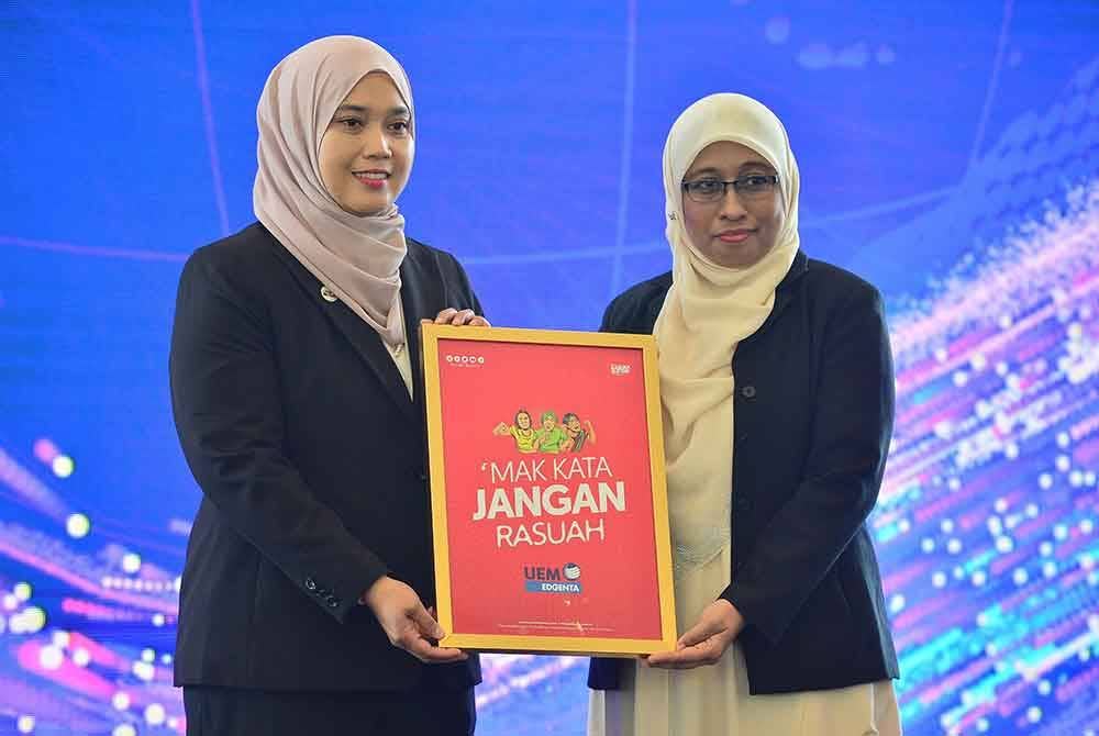 (Dari kanan) Norhayati menyerahkan stiker kereta kepada Farhah sempena Pelancaran Integrity Day 2024 pada Rabu. Foto ASRIL ASWANDI SHUKOR