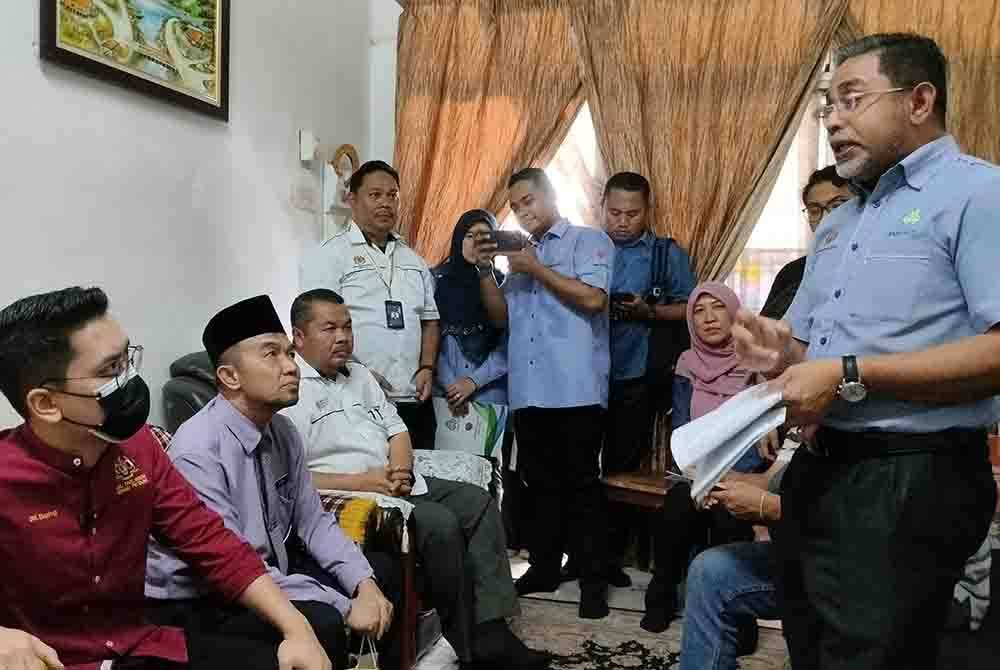 Mohammed Taufiq (kiri) ketika hadir ke rumah lima beradik yatim piatu di Taman Pahlawan Sungai Petani Kedah.