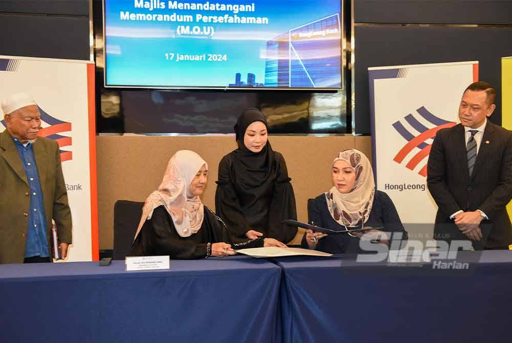 Dafinah (duduk, kanan) bersama Ida Riswana (duduk, kiri) ketika menandatangani MoU antara Hong Leong Islamic Bank dan Andalusia Travel & Tour di Menara Hong Leong, Bukit Damansara, Kuala Lumpur. Foto Sinar Harian-MOHD RAFIQ REDZUAN HAMZAH