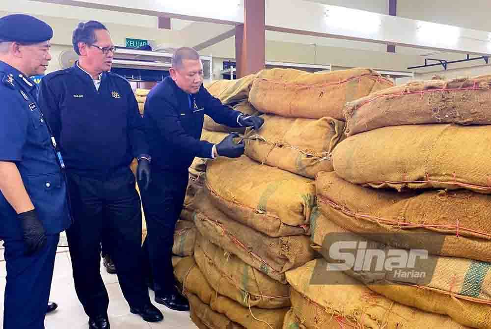 Zailani (tengah) memeriksa bahan rampasan.