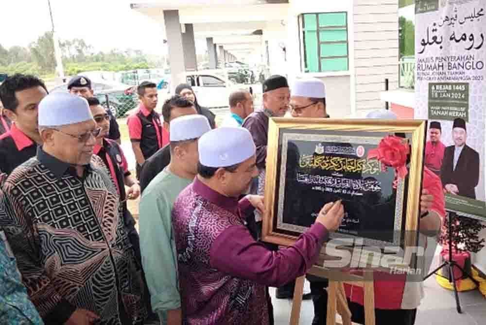Nasuruddin menandatangani plak sebagai gimik penyerahan banglo kepada johan Tilawah Al-Quran Peringkat Antarabangsa 2023, Muhammad Qayyim Nizar Sarimi pada Khamis.