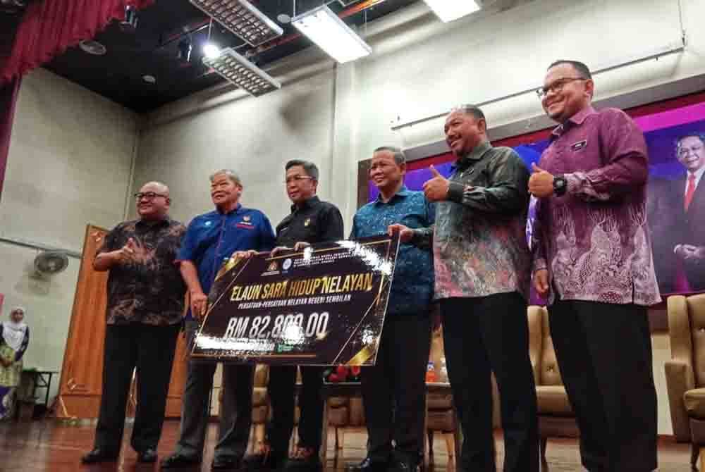 Aminuddin (tiga kanan) dan Jalaluddin (tiga kiri) ketika menyampaikan replika cek berkenaan kepada wakil nelayan.