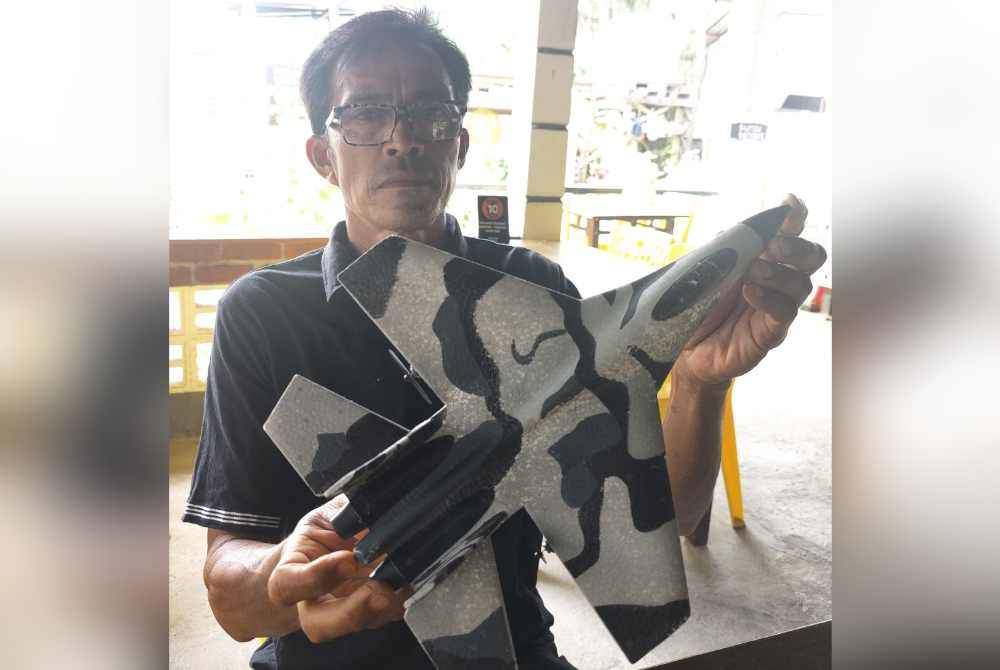 Rahman bersama replika kecil Sukhoi yang menjadi sumber inspirasi kepadanya untuk membina replika lebih besar