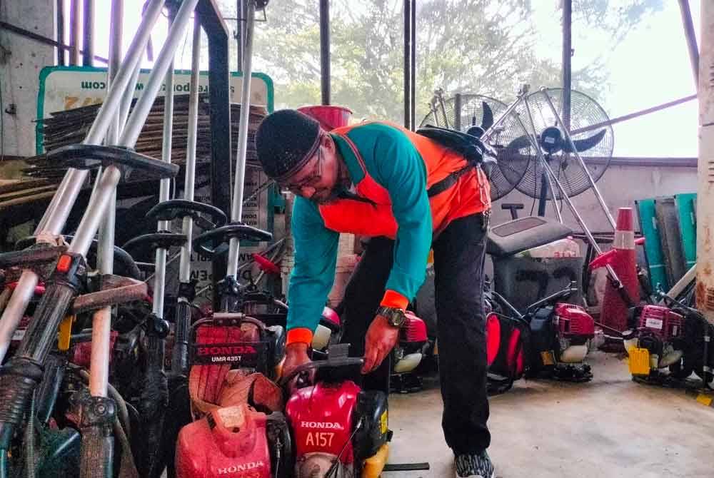 Zulkifli memeriksa mesin rumput sebagai tugas rutin hariannya.