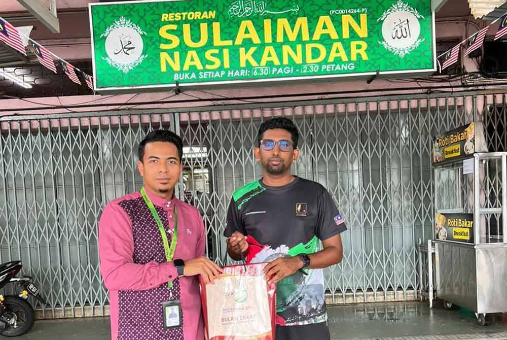 Mohamed Imran (kanan) tidak lupa menunaikan tanggungjawab membayar zakat perniagaan setiap tahun.