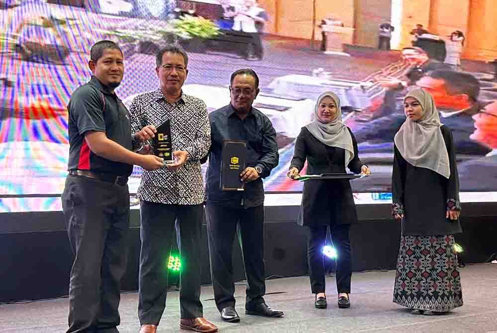 Ir Mohd Suhaili (tengah) bersama Tuan Zainal Abidin (dua dari kiri) menyampaikan anugerah kepada kakitangan JKR yang cemerlang pada 2023.