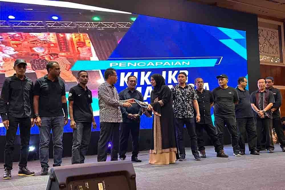 Ir Mohd Suhaili (lima dari kiri) mengiringi Tuan Zainal Abidin (empat dari kiri) menyampaikan penghargaan kepada kakitangan JKR yang cemerlang.