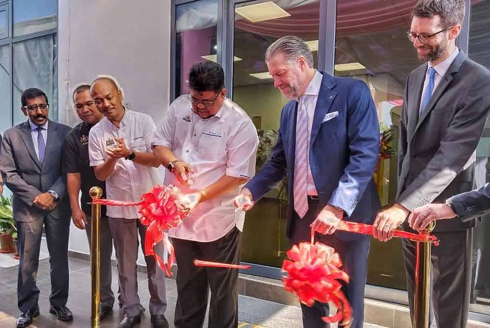 Ab Rauf (tiga dari kanan) memotong reben sebagai sebagai simbolik menyempurnakan bangunan baharu kilang pengeluar cip mikro di Kawasan Perindustrian Angkasa Nuri, Durian Tunggal, di sini, pada Isnin.