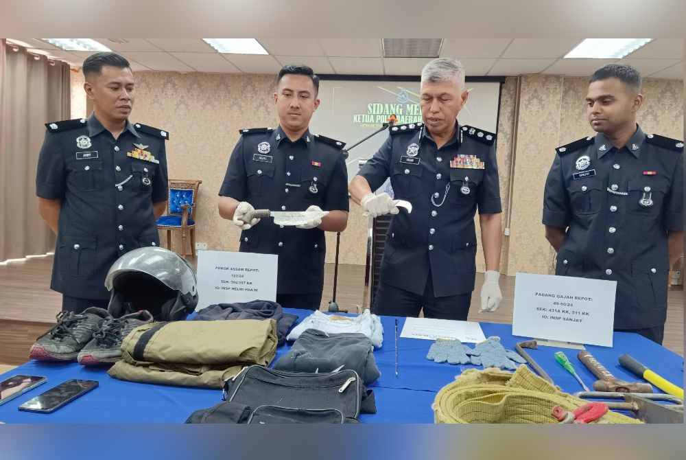 Mohamad Nasir (dua dari kanan) menunjukkan senjata jenis kerambit yang dipercayai digunakan suspek ketika melakukan samun dan ragut sekitar Taiping.