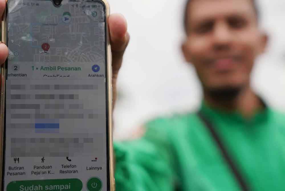 Seorang penghantar p-hailing menunjukkan kadar upah penghantaran diterimanya ketika gerakan 'Tuntutan Hak Rider Se-Malaysia' di pekarangan pejabat syarikat penyedia perkhidmatan, dekat Petaling Jaya pada Jumaat. Foto Sinar Harian-ROSLI TALIB