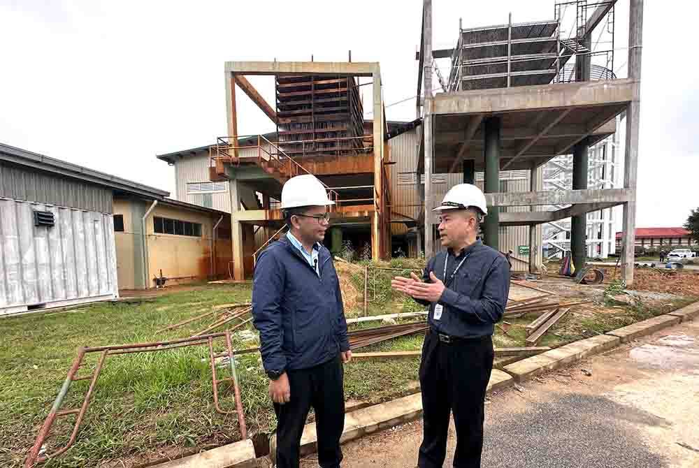 Akmal Nasrullah (kiri) mendengar penerangan daripada Izani (kanan) berkait LRA Kampung Teluk.