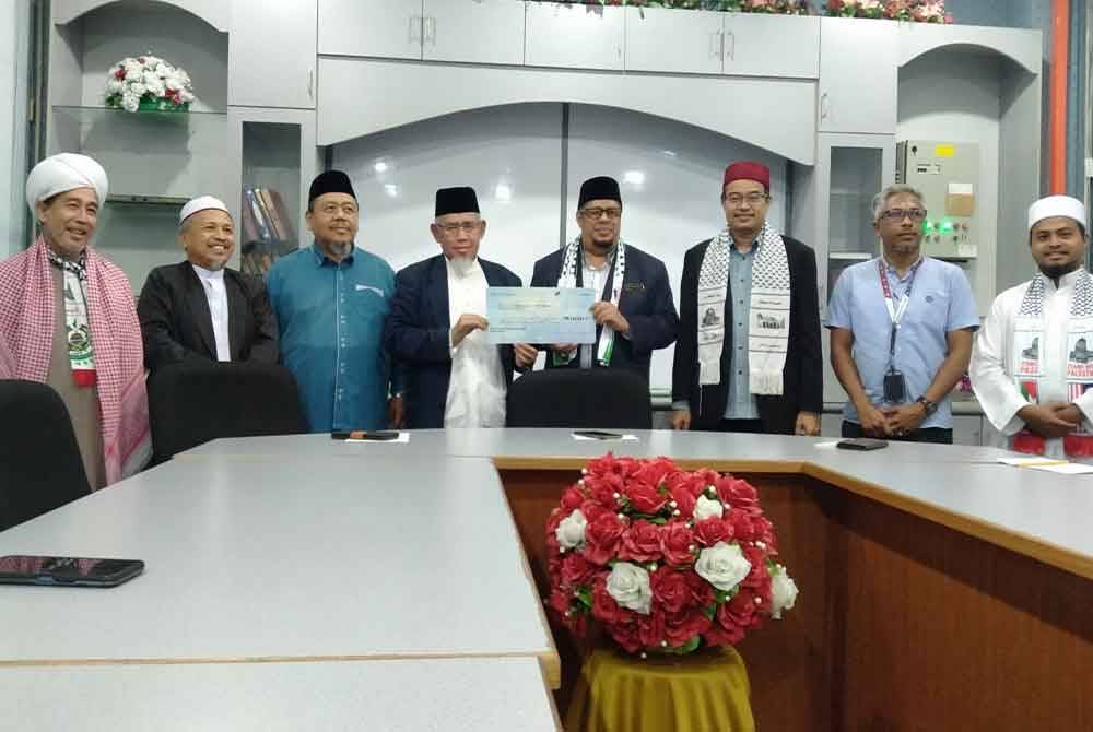 Harith Fadzilah (empat dari kanan) menyerahkan replika cek sumbangan dari Tabung Bencana dan Kemanusiaan Masjid-Masjid Negeri Perak kepada Mohd Azmi di Masjid Negeri Perak di sini pada Isnin.